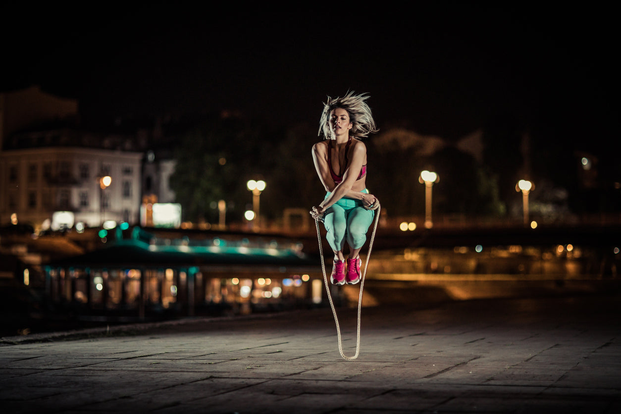 young woman skipping rope outdoors