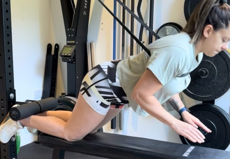 A woman exercising using the Forte Fitness nordic cable attachment.